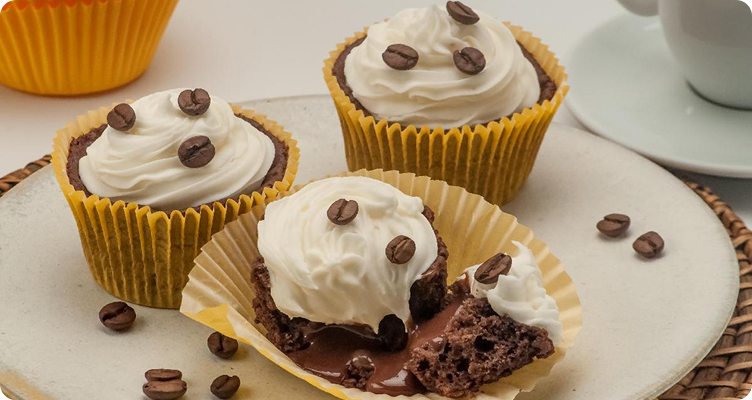 Imagem de alguns cupcakes com grãos de café e chantilly